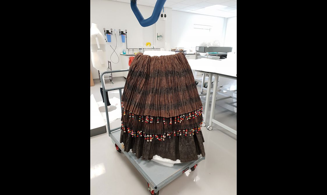 A layered brown skirt with beads on a custom storage mount.